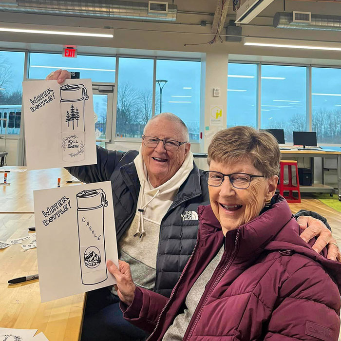 Residents proudly display their personalized water bottle designs during a creative session at Community College.