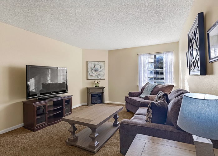 Comfortable and inviting living room area in The Cambridge Senior Living community, featuring cozy furniture, a large TV, and tasteful decorations.