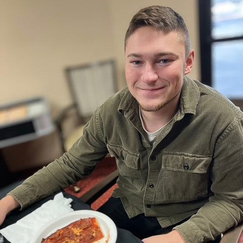 A team member smiles while enjoying a meal at the community.