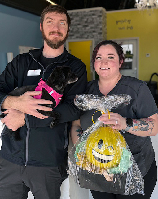 A Cambridge Senior Living team member presents a gift basket to a local business owner.