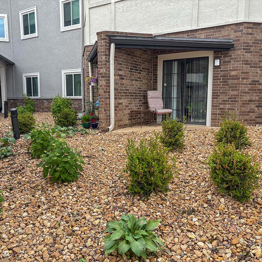 Freshly landscaped rock beds filled with plants at The Cambridge Senior Living.